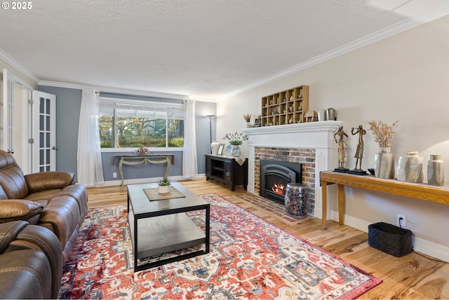 living room featuring a fireplace, hardwood / wood-style flooring, a textured ceiling, and crown molding