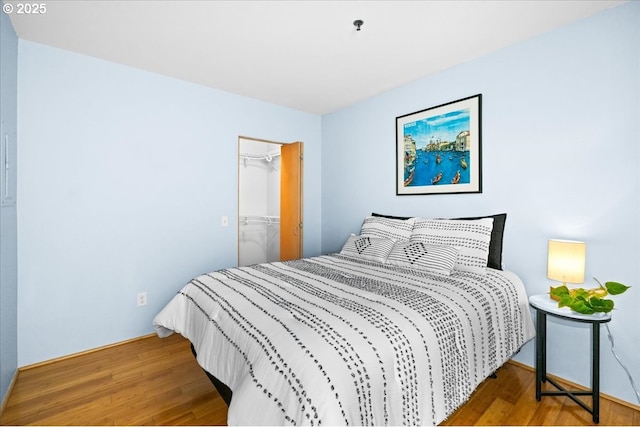310 NW Uptown Ter Unit 1A, Portland, OR 97210 - bedroom featuring wood finished floors, a walk in closet, and a closet