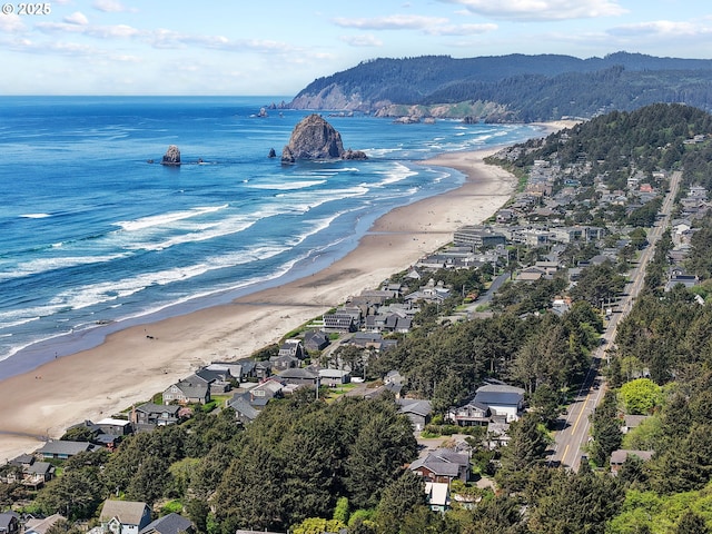 bird's eye view with a water and mountain view, a view of the beach, and a residential view