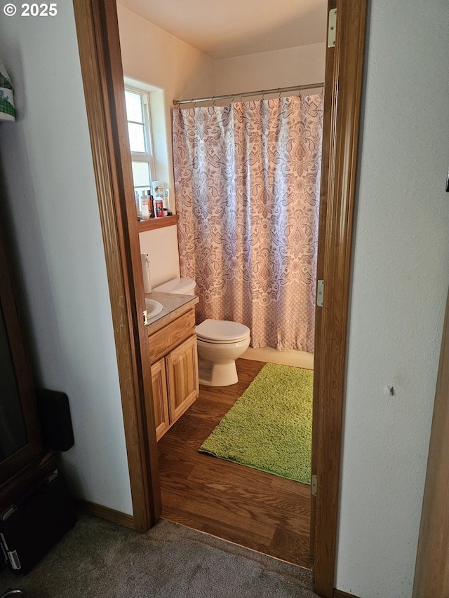 510 NE Yamhill St, Sheridan, OR 97378 - full bath featuring wood finished floors, vanity, a shower with shower curtain, and toilet