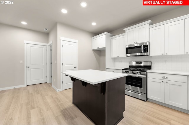 kitchen with white cabinets, a center island, and appliances with stainless steel finishes