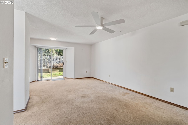 empty room with a ceiling fan, light carpet, a textured ceiling, and baseboards