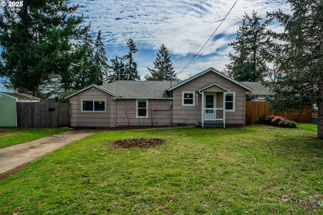 view of front of property with a shingled roof, fence, and a front yard