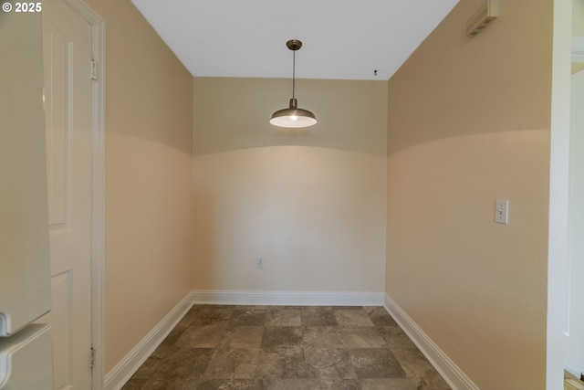 unfurnished dining area featuring baseboards