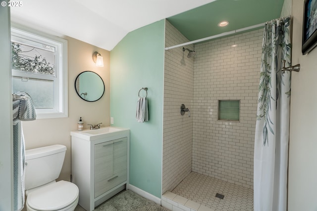 full bath with toilet, vanity, baseboards, vaulted ceiling, and a stall shower