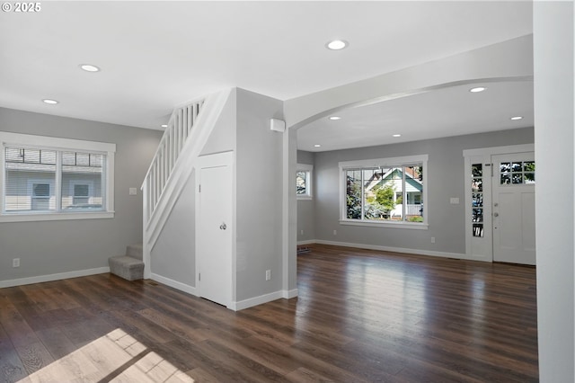 220 Adams Ave, Silverton, OR 97381 - unfurnished living room with arched walkways, recessed lighting, dark wood-style floors, stairs, and baseboards