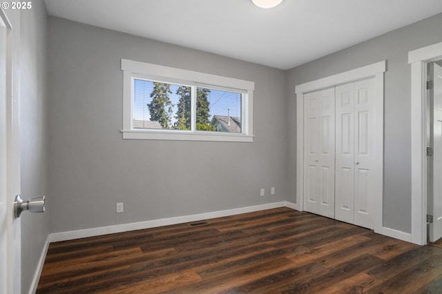 220 Adams Ave, Silverton, OR 97381 - unfurnished bedroom with baseboards, dark wood-type flooring, and a closet
