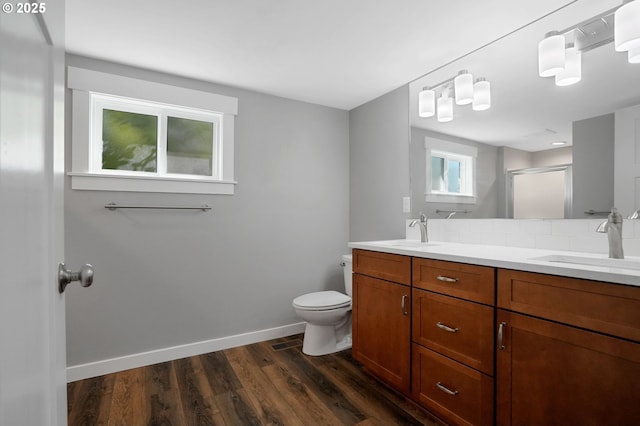 220 Adams Ave, Silverton, OR 97381 - bathroom with a shower stall, wood finished floors, double vanity, toilet, and baseboards