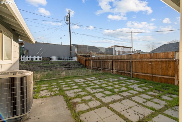 view of yard with central air condition unit and a patio