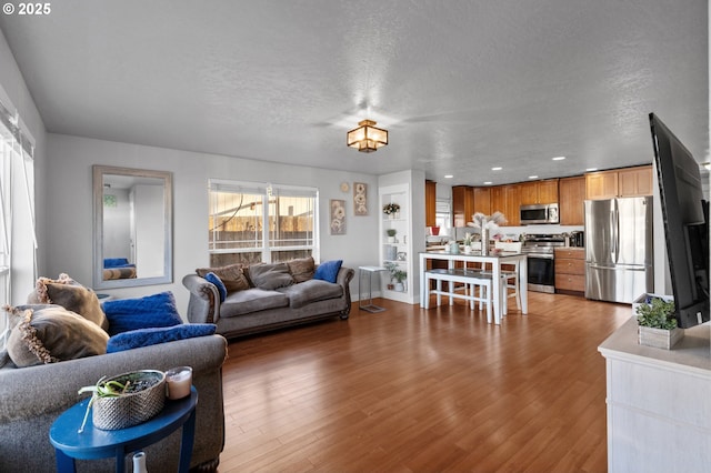 living room with dark wood-type flooring, plenty of natural light, and a textured ceiling