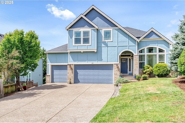 view of front facade with fence, an attached garage, a front lawn, brick siding, and concrete driveway