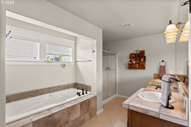bathroom featuring a bath, visible vents, a shower stall, vanity, and baseboards