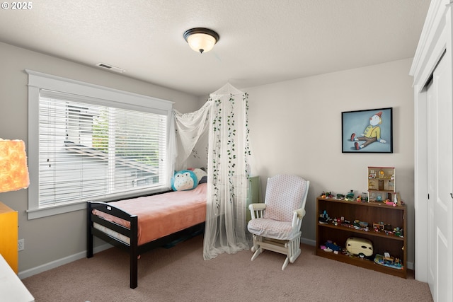 carpeted bedroom featuring baseboards, visible vents, and a closet