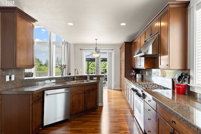kitchen featuring a sink, appliances with stainless steel finishes, tile counters, and under cabinet range hood