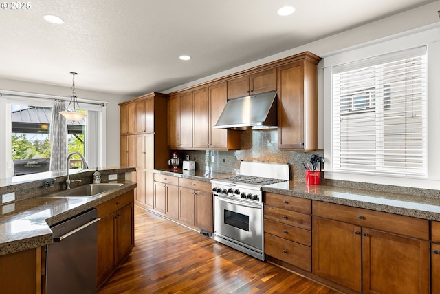 kitchen featuring decorative backsplash, appliances with stainless steel finishes, a sink, dark wood-style floors, and under cabinet range hood