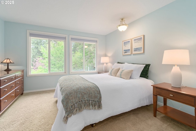 bedroom with baseboards and light colored carpet