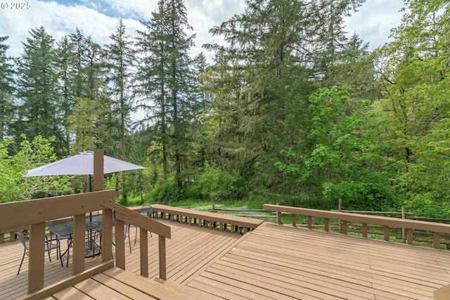 wooden deck with a wooded view