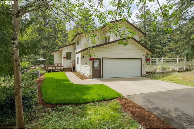 tri-level home with a front yard, a deck, a garage, fence, and concrete driveway