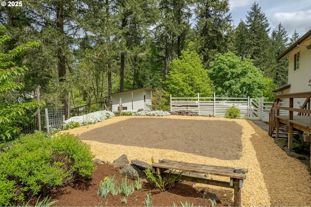 view of yard with fence, an outbuilding, and a shed