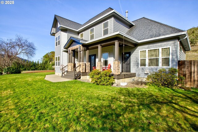 rear view of house with a lawn and a porch