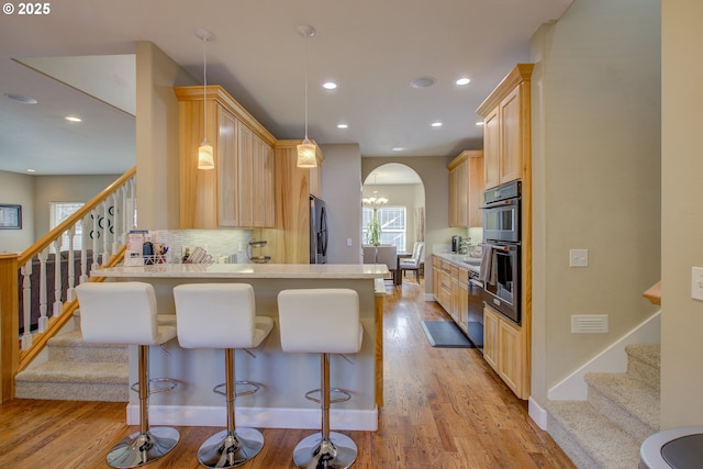 459 Oak Valley Loop, Winchester, OR 97495 - kitchen with appliances with stainless steel finishes, light brown cabinets, a peninsula, backsplash, and arched walkways