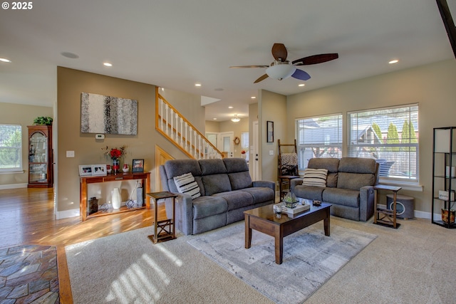 carpeted living room featuring a tiled fireplace and ceiling fan