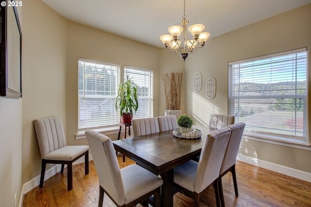 dining space with sink, light hardwood / wood-style flooring, and a notable chandelier