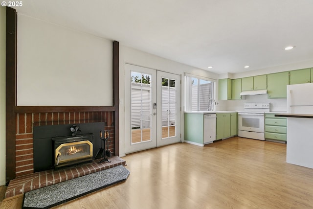 6125 SW Erickson Ave, Beaverton, OR 97008 - kitchen with green cabinetry, white appliances, under cabinet range hood, light wood-style flooring, and light countertops