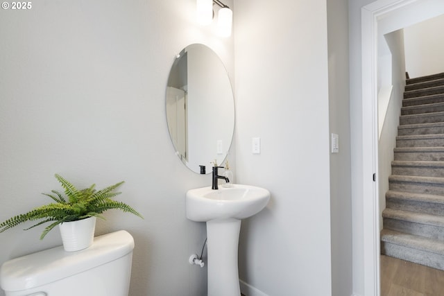 bathroom featuring wood-type flooring, sink, and toilet