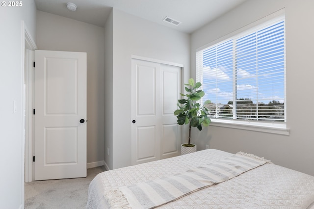 bedroom with light carpet and a closet