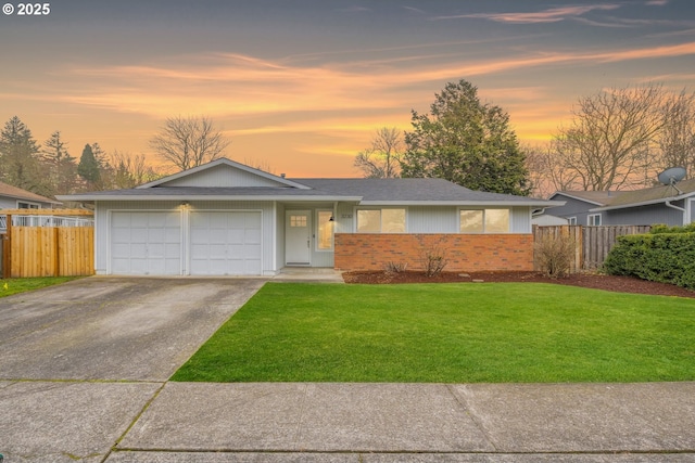 ranch-style house featuring a yard and a garage