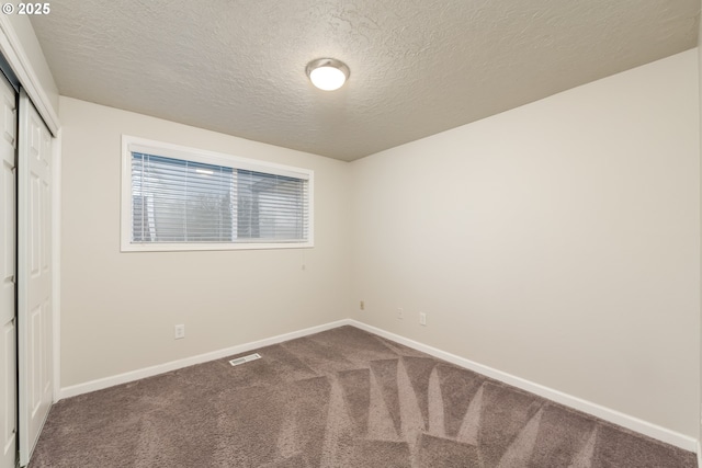 unfurnished bedroom with a textured ceiling, a closet, and carpet floors