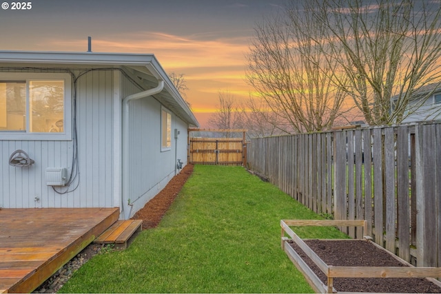 yard at dusk featuring a wooden deck