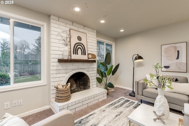 living room with a brick fireplace and carpet floors