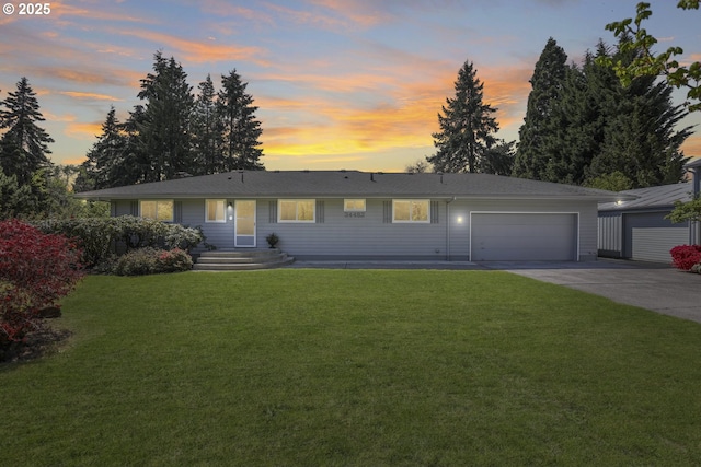 ranch-style home featuring a garage, concrete driveway, and a lawn