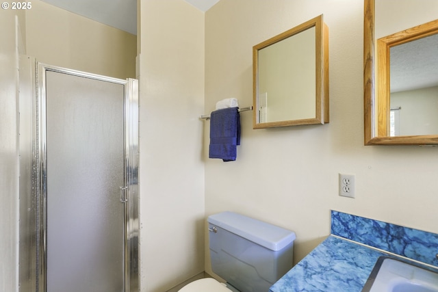 bathroom with a shower stall and toilet