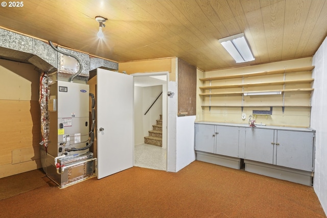below grade area featuring wood ceiling, stairway, light colored carpet, and heating unit