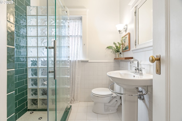 2083 NW Johnson St Unit 34, Portland, OR 97209 - bathroom featuring tile walls, a stall shower, tile patterned floors, toilet, and wainscoting
