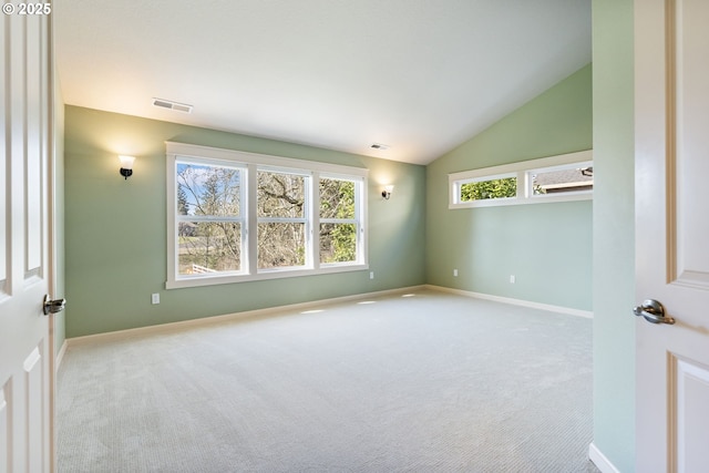 unfurnished room with baseboards, visible vents, vaulted ceiling, and carpet flooring