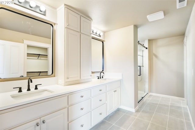 full bath featuring double vanity, a sink, visible vents, and a shower stall