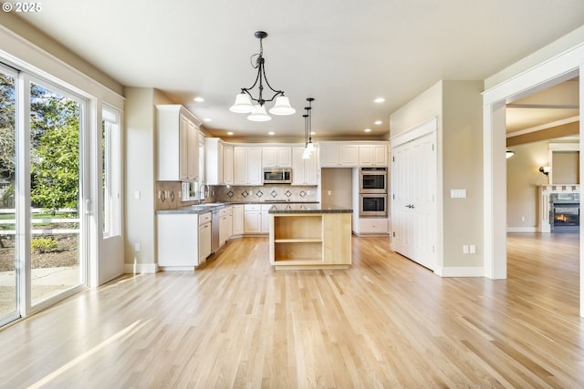 kitchen with light wood-style flooring, stainless steel appliances, white cabinetry, decorative backsplash, and open shelves