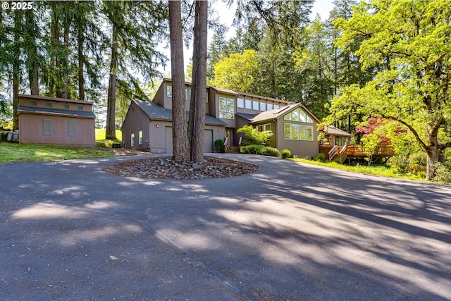 view of front of property featuring curved driveway and a garage