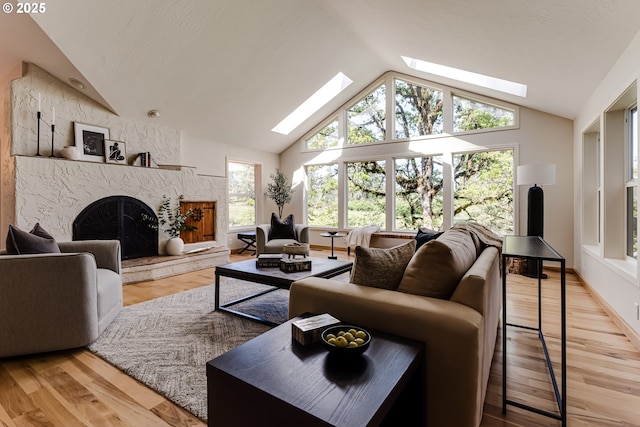living room featuring vaulted ceiling with skylight, a high end fireplace, and wood finished floors