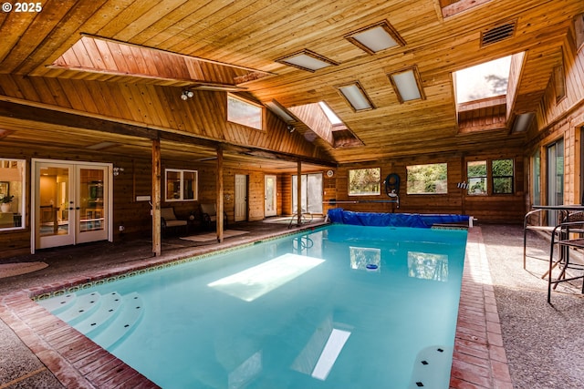 view of pool with a skylight, french doors, and a covered pool
