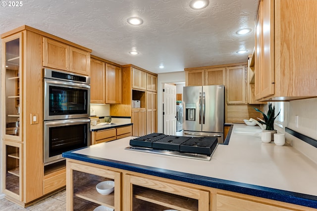 kitchen featuring recessed lighting, light brown cabinets, stainless steel appliances, and a peninsula