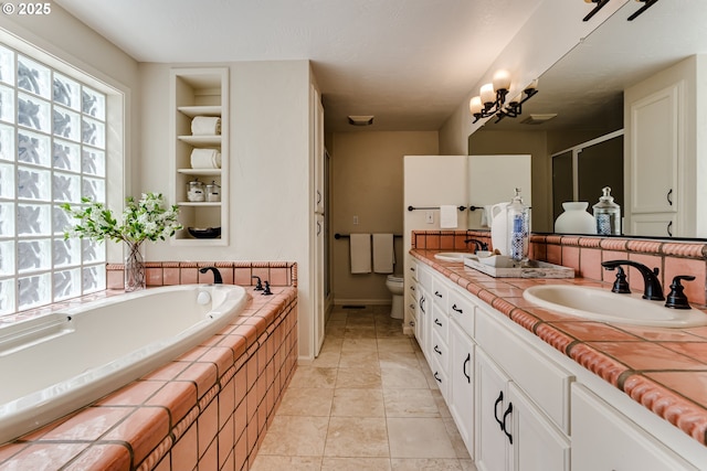 bathroom with double vanity, a sink, a garden tub, and a stall shower