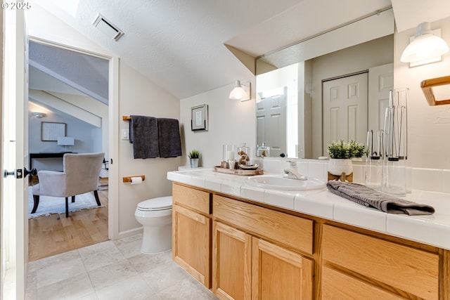 bathroom with vanity, toilet, tile patterned floors, vaulted ceiling, and visible vents