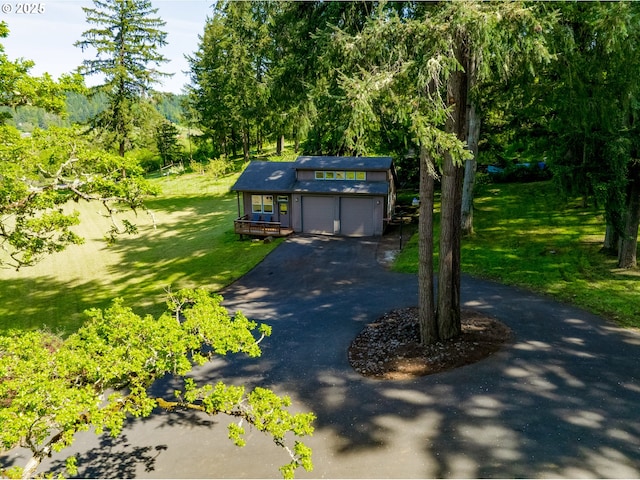 view of front of property featuring an attached garage, driveway, and a front yard