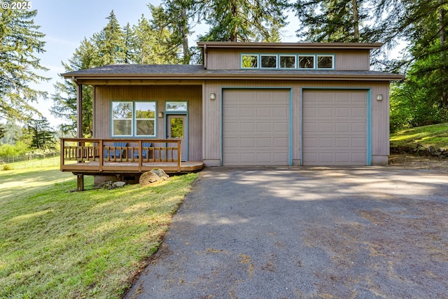 view of front facade featuring a deck, a garage, a front yard, and aphalt driveway