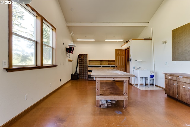 recreation room featuring baseboards, concrete floors, and high vaulted ceiling